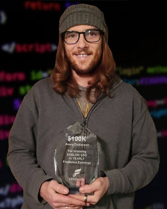 Avery holding his $100k yearly freelance earnings award