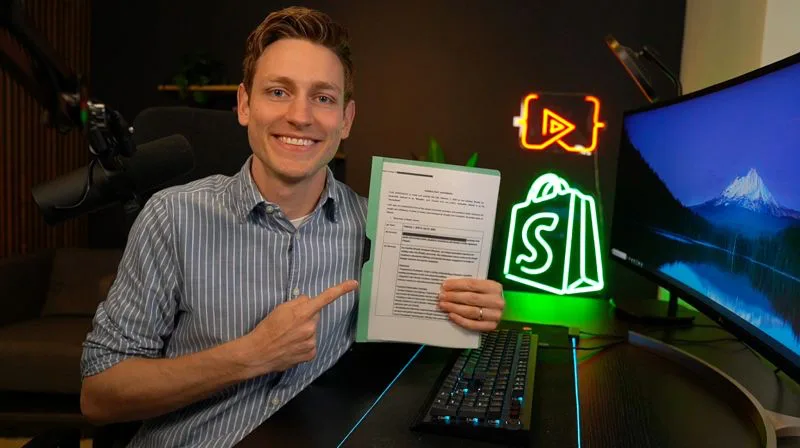 Jan holding his Shopify Academy contract in his recording studio