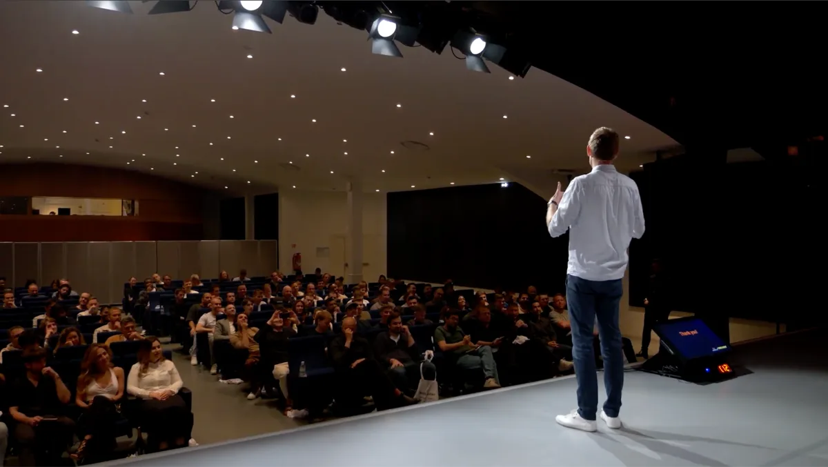 Jan on stage speaking to an auditorium audience